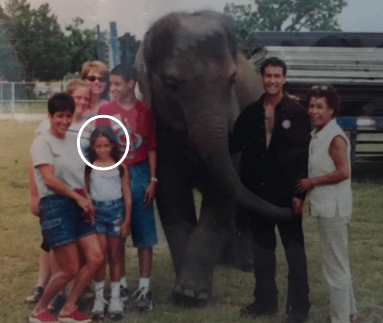Young Anissa, circled, standing with her family beside one of her uncle's elephants